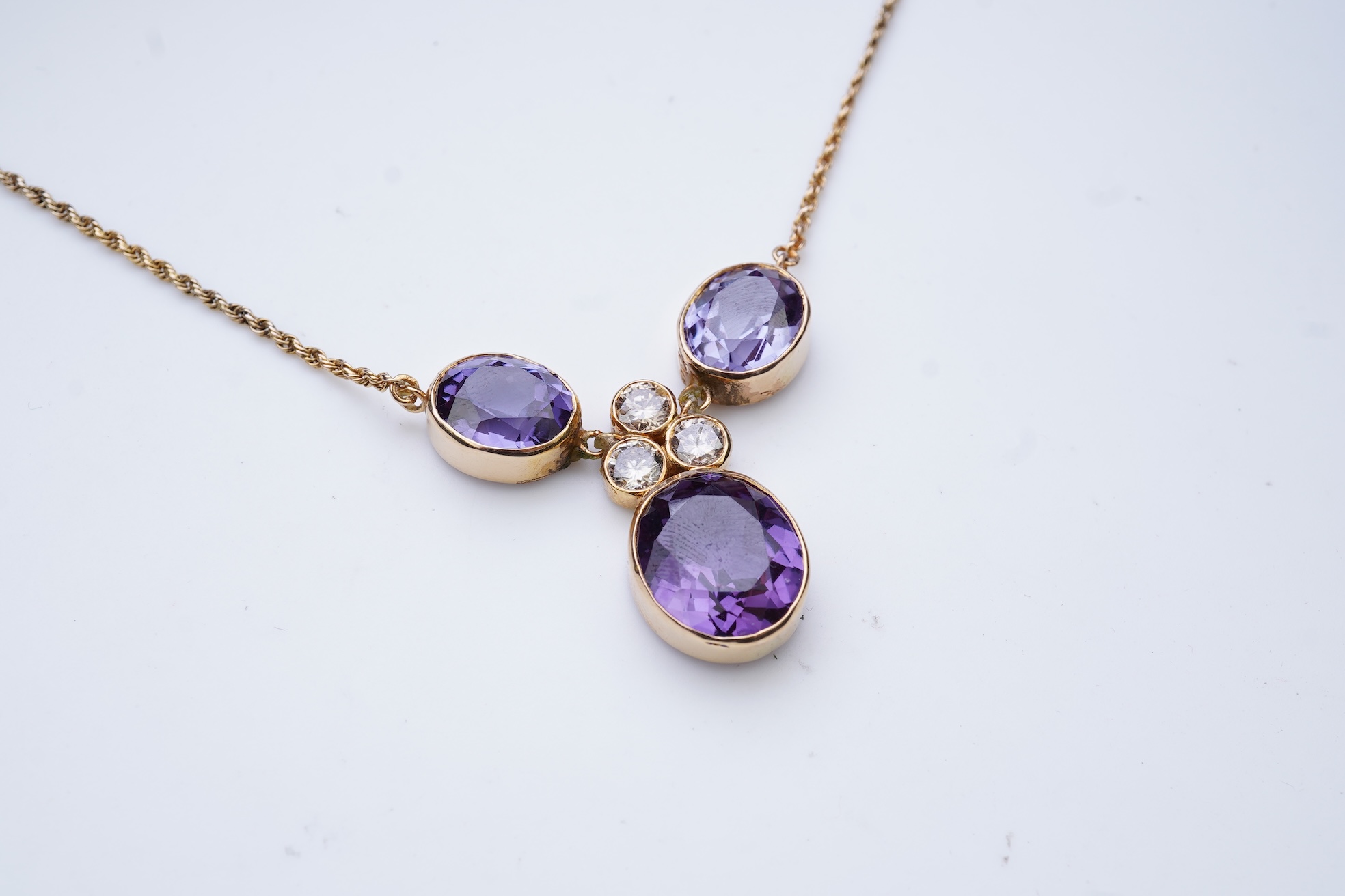 A synthetic colour-change sapphire and diamond pendant necklace